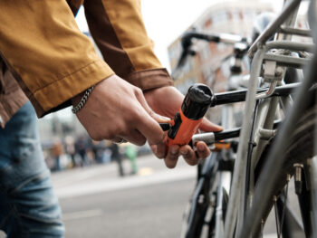 Cyclist securing bike with u-lock on city street