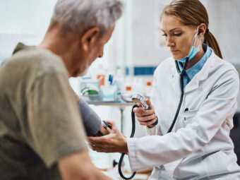 Female doctor doctor measuring senior man's blood pressure at medical clinic.